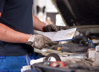 Mobile mechanic in Jackson MS recording results during a car diagnostic inspection