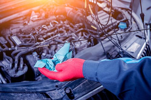 Mobile mechanic in Jackson MS checking engine oil level during an on-site service