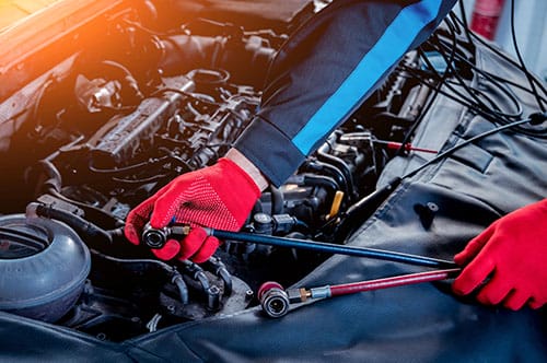 Mobile mechanic in Jackson MS tightening engine components during an on-site car repair